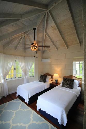 a bedroom with two beds and a ceiling fan at Gully Point in Saint James