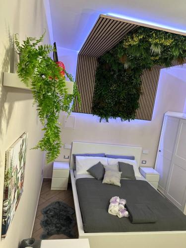 a bedroom with a bed with plants on the wall at Tropical Holiday House in Catania