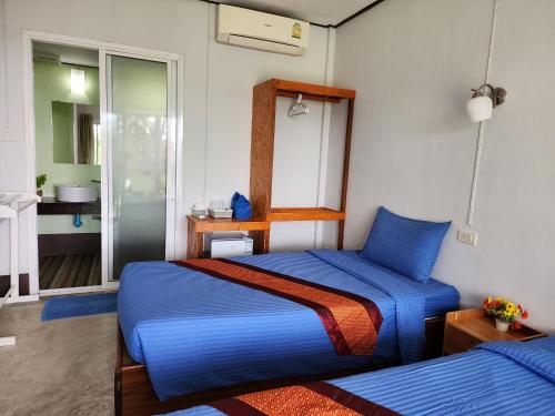 a bedroom with a blue bed and a bathroom at S Beach Resort in Ko Kood