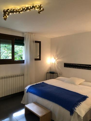 a bedroom with a large bed with a blue blanket at Acogedora casa en la montaña in La Baronia de Rialb