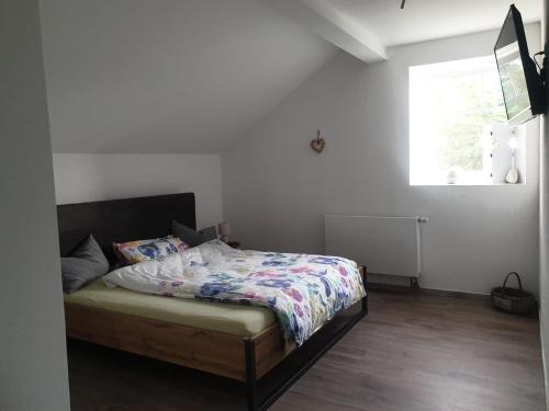 um quarto com uma cama com um edredão e uma janela em Ferienwohnung Witten Gederbach em Witten
