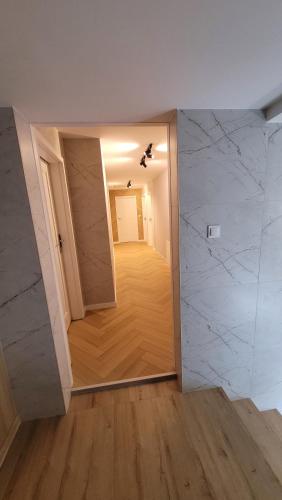 a room with a hallway with white marble walls at Hotel & Restauracja Wróblewscy in Karniewo
