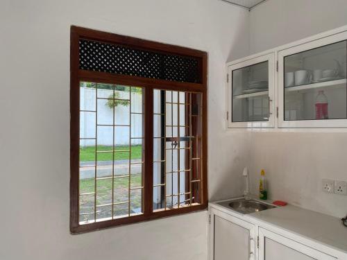 una cucina con finestra accanto a un lavandino di Island Star POOL & SPA a Galle