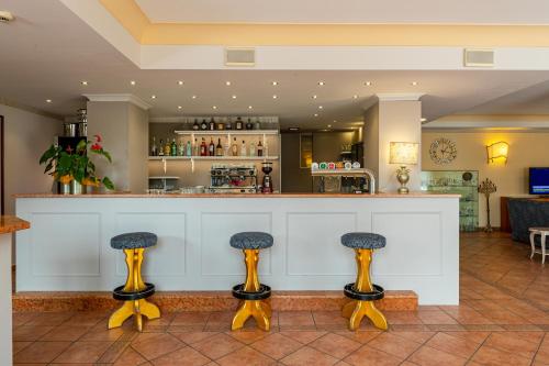 a bar with two stools in front of a counter at Hotel Romantic in Cavaion Veronese