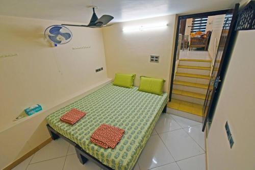 a room with a bench with two green pillows on it at galaxy inn Home stay-white town in Puducherry