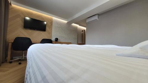 a hotel room with a bed and a tv on the wall at Hotel & Restauracja Wróblewscy in Karniewo
