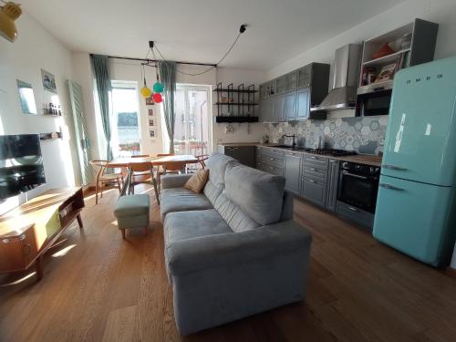 uma sala de estar com um sofá e uma cozinha com uma mesa em Terrazza18 em Milão