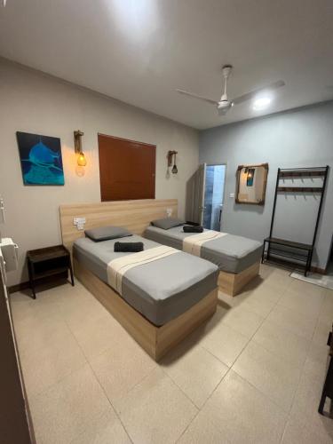 a bedroom with two beds and a mirror at Dive Villa Thoddoo in Thoddoo