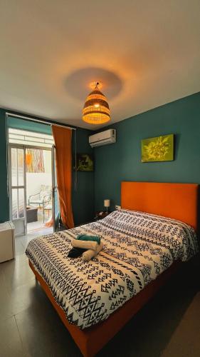 a bedroom with a bed with an orange head board at La Pita Beach house in Almería