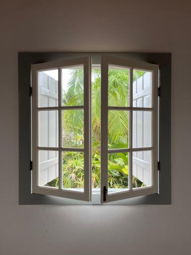 an open window with a view of a palm tree at Casa Arte Cabore in Paraty