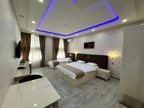 a hotel room with two beds and a blue light at Starway Hotel in Lankaran