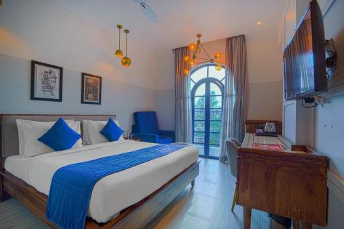 um quarto com uma cama grande e uma janela em The Belmonte House By Levelup em Udaipur