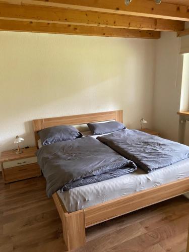 Una cama con almohadas azules en un dormitorio en Ferienwohnung im Herzen Graubündens, en Surava