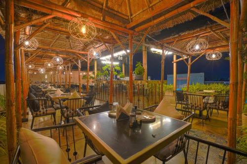 Un restaurante con mesas, sillas y luces. en The Belmonte House By Levelup, en Udaipur