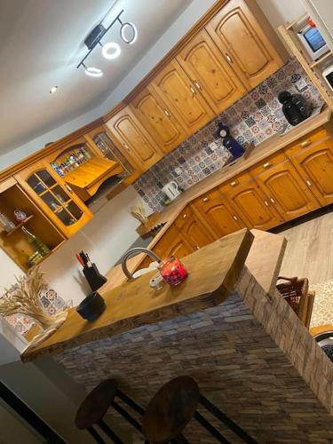 une cuisine avec une table en bois au milieu dans l'établissement Maison cosy, terrasse & jardin, à Imphy