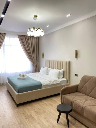 - une chambre avec un lit et un canapé dans l'établissement Batysmura Бизнес, à Atyraū