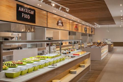 a restaurant with a buffet of food on display at Serenade All Suites - Adults Only Resort in Punta Cana