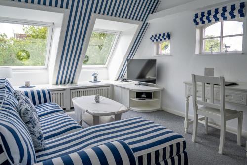 a living room with blue and white striped furniture at Inselhotel Arfsten in Wyk auf Föhr