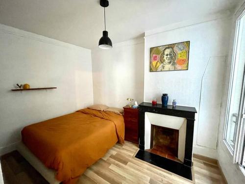 1 dormitorio con 1 cama y chimenea en Charmant appartement au cœur du 11e arrondissement en París