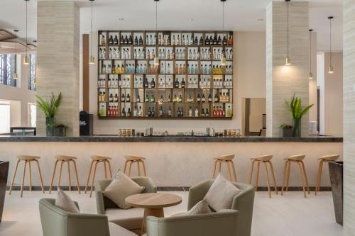 a bar at a hotel with chairs and a counter at Serenade All Suites - Adults Only Resort in Punta Cana