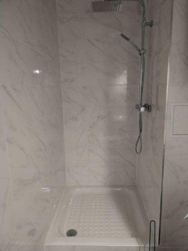 La salle de bains blanche est pourvue d'une douche et d'une baignoire. dans l'établissement Appartement LA Grande Motte pour 5 personnes maximum, à La Grande Motte