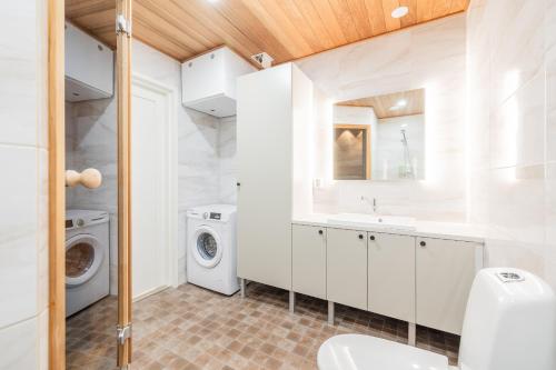 a bathroom with a sink and a washing machine at Nordic Wooden House in Rovaniemi
