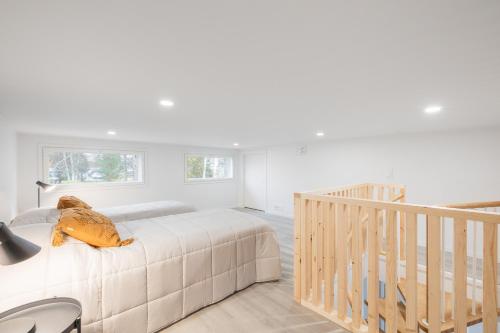 a white bedroom with a bed and a staircase at Nordic Wooden House 3 in Rovaniemi