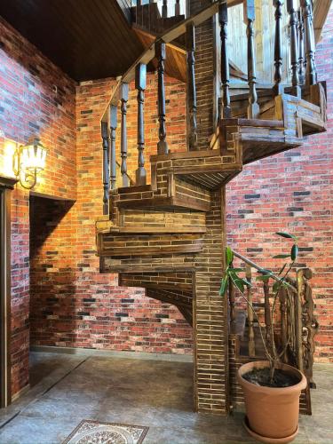 a wooden staircase in a brick wall with a potted plant at Starway Hotel in Lankaran