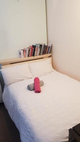 a bed with a red hat and two stuffed animals on it at Double bedroom in Raynes Park in London
