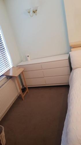 a room with a bed and a table and a bath tub at Double bedroom in Raynes Park in London