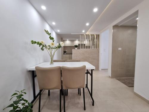uma cozinha e sala de jantar com uma mesa branca e cadeiras em Appartement de luxe près de la mer em Nabeul
