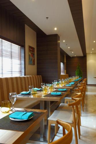 a long dining room with wooden tables and chairs at Distrikt 9 in Palakkad