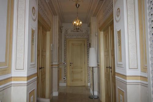 a hallway with a yellow door and a chandelier at Stanze Degli Aceri in Murazzano