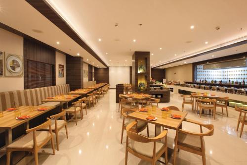 a restaurant with wooden tables and chairs and a bar at Distrikt 9 in Palakkad
