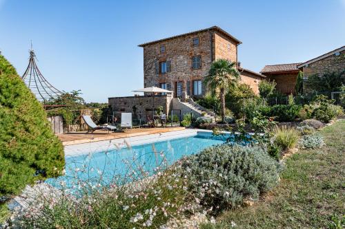 a house with a swimming pool in front of a building at Maison de Pagneux in Lachassagne