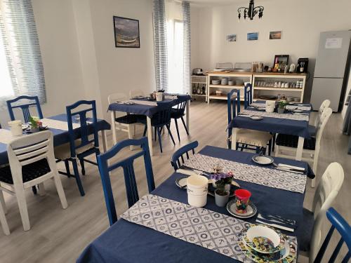 a dining room with blue tables and chairs at B&B Puvogel in Porticello