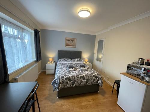 a bedroom with a bed and a table in it at Kensal Lodge 2 Guest House in London