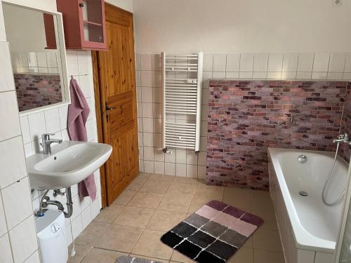 a bathroom with a sink and a bath tub and a sink at Wohnen in Loriots Wasserstadt mit Kamin und MagentaTV in Brandenburg an der Havel