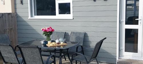 a table with chairs and a vase of flowers at High Tide in Braunton