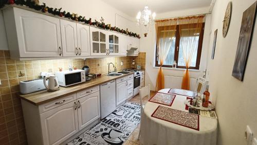 a kitchen with white cabinets and a counter top at Patak apartman in Eger