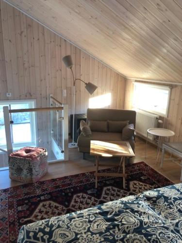 ein Wohnzimmer mit einem Sofa und einem Stuhl in der Unterkunft Semi-detached house with lakeview in Tällberg 6 beds in Tällberg