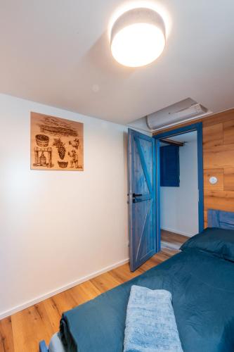 a bedroom with a bed and a blue door at Prostě Sklípek in Starý Poddvorov
