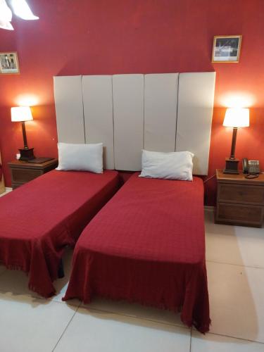 two beds in a room with red walls at Whitestar Guesthouse in Salina