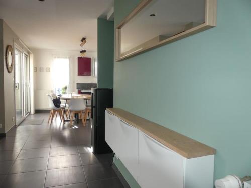 une cuisine avec un comptoir, une table et des chaises dans l'établissement Maison centre et plages, à Plouhinec