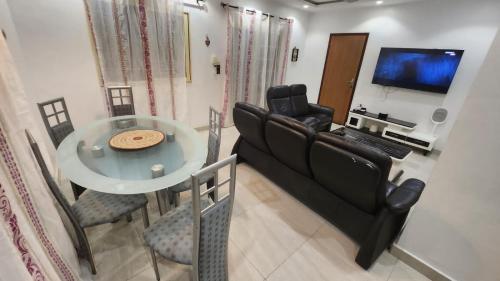 a living room with a couch and a table with chairs at Comme chez soi in Kika