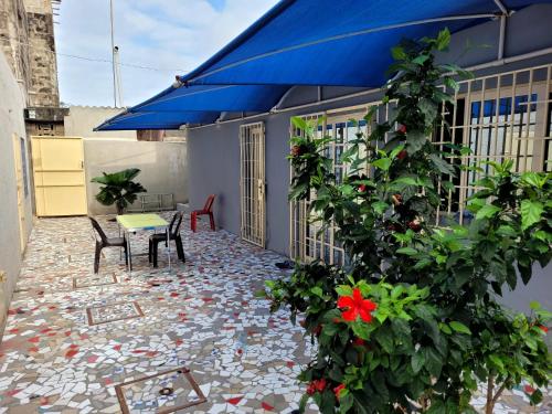 une terrasse avec une table et un parasol bleu dans l'établissement Comme chez soi, à Kika