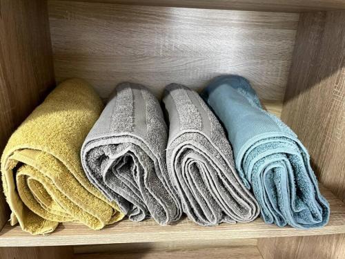 une étagère avec quatre types de serviettes différents dans l'établissement Appart’ Cosy (E) proche Paris/Roissy CDG, à Tremblay-en-France