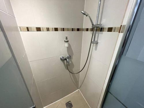 La salle de bains est pourvue d'une douche et d'une porte en verre. dans l'établissement Appart’ Cosy (E) proche Paris/Roissy CDG, à Tremblay-en-France