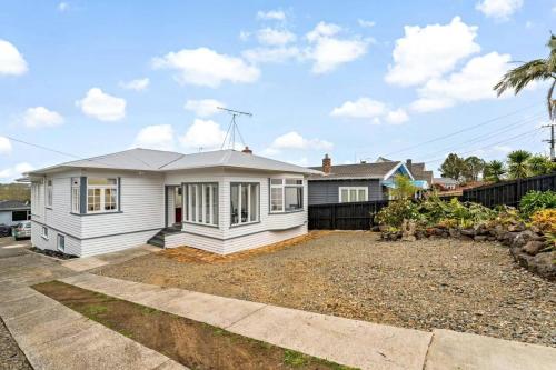 a white house with a driveway in front of it at Albert.T Home in Auckland