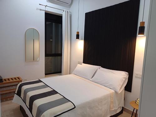 a bedroom with a large white bed with a black headboard at Colon 13 in Zamora